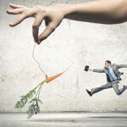Businessman chasing after a dangling carrot incentive